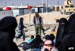 FILE - A member of Kurdish internal security stands guard at the Kurdish-run al-Hol camp, in northeastern Syria, Jan. 28, 2021.