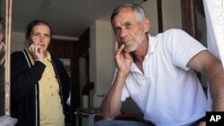 Bosnian Muslim couple Halida, 52, left, and Abaz Dudic, 56, an unemployed former war camp prisoner, stand near a window inside their shelter at the collective center for refugees near the northern Bosnian town of Zivinice, 130 kms north of Sarajevo, where