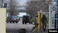 Sejumlah pasukan Rusia menjaga gerbang masuk PLTN Zaporizhzhia dalam kunjungan anggota Badan Energi Atom Internasional (IAEA) ke PLTN tersebut pada 29 Maret 2023. (Foto: Reuters/Alexander Ermochenko)