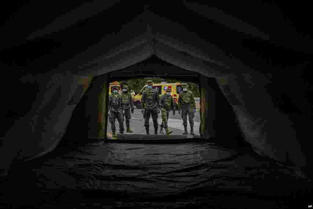 Soldados del ejército español montan una carpa para ser utilizadas por pacientes del hospital, durante el brote de coronavirus en Madrid, España. 