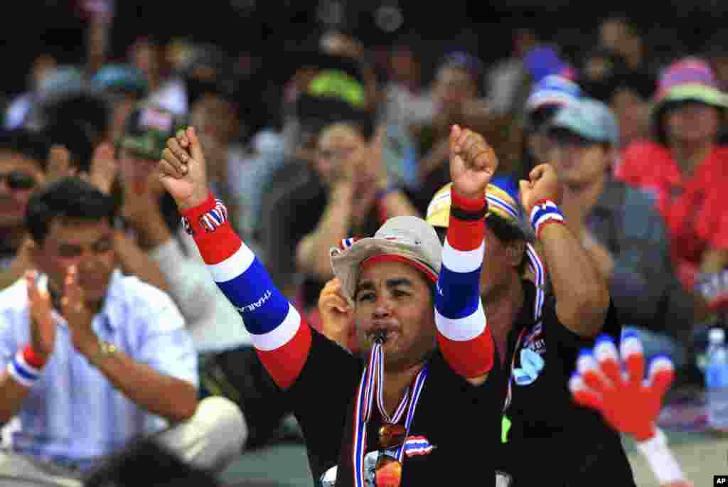 An anti-government protester raises his hands as he listens to a speech by protest leader Suthep Thaugsuban during a rally in Bangkok, Feb. 25, 2014. 