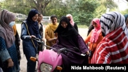 Humaira Rafaqat teaches women how to ride a bike while wearing an abaya, during a training session as part of the "Women on Wheels" program organized by the traffic police department in Lahore, Pakistan, October 1, 2024. (REUTERS/Nida Mehboob)