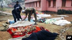 An Indian official inspects bodies covered by blankets in West Midnapore district's Sildha, West Bengal state, 16 Feb 2010