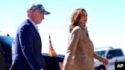 Democratic presidential nominee Vice President Kamala Harris, followed by Sen. Mark Kelly of Arizona, walks after arriving in Douglas, Ariz., Sept. 27, 2024.