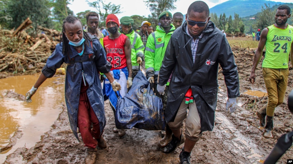 FILE - Kenya Red Cross workers and volunteers, carry a man's body retrieved from mud, after floodwater washed away houses, in Kamuchiri Village Mai Mahiu, Nakuru County, Kenya, Tuesday, April 30, 2024. (AP Photo/Patrick Ngugi, File)