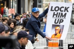 Demonstrant u New Yorku drži transparent na kojem piše "Uhapsite Trumpa".