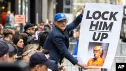 Demonstrant u Njujorku drži transparent na kojem piše "Uhapsite Trampa"