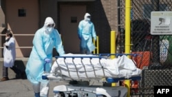 Bodies are moved to a refrigeration truck serving as a temporary morgue at Wyckoff Hospital in the Borough of Brooklyn on April 6, 2020 in New York.