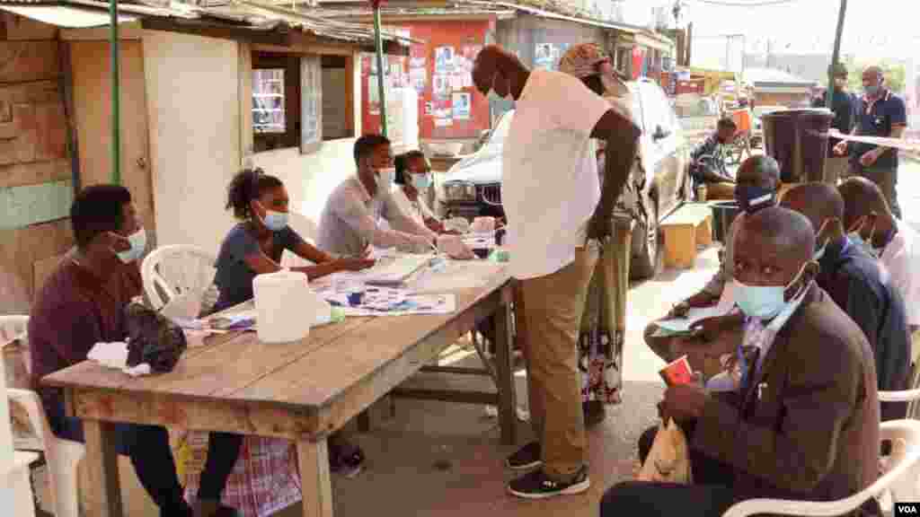 A voter waits for his ID to be checked before casting his ballot on election day in Accra, Ghana, Dec. 7, 2020. (Photo: Peter Clottey, Issah Ali / VOA)