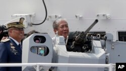 FILE - Philippine Transportation Secretary Arthur Tugade inspects the prototype of the 50-caliber Remote Controlled Weapons System mounted on the new Philippine Coast Guard multi-purpose vessel, Oct. 10, 2019.