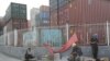 Laborers rest next to containers outside a logistics center near Tianjin Port, in northern China, May 16, 2019.