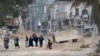 FILE - Residents of the West Bank refugee camp of Nur Shams, near Tulkarem, evacuate their homes as the Israeli military continues its operation in the area on Feb. 11, 2025. 