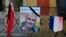 A portrait of mountain guide Frenchman Herve Gourdel hangs near a French flag outside the town hall in Saint-Martin-Vesubie, Sept. 25, 2014.