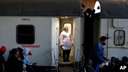 FILE - A health care worker stands at the door of the Phelophepa eye clinic carriage, in Tembisa, east of Johannesburg, South Africa, Aug. 22, 2024.