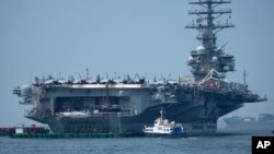 Sebuah kapal mendekati kapal induk AS USS Ronald Reagan (CVN 76) di pelabuhan di Manila, Filipina pada 14 Oktober 2022. (AP/Aaron Favila)