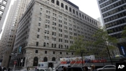 Pedestrians pass the Federal Reserve Building, New York, Oct. 17, 2012.