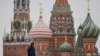 A security specialist stands guard near the Spasskaya tower of the Kremlin and St. Basil’s Cathedral in central Moscow, Feb. 13, 2025.