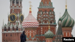 A security specialist stands guard near the Spasskaya tower of the Kremlin and St. Basil’s Cathedral in central Moscow, Feb. 13, 2025.