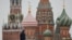 A security specialist stands guard near the Spasskaya tower of the Kremlin and St. Basil’s Cathedral in central Moscow, Feb. 13, 2025.