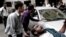 This photo released by the Syrian official news agency SANA shows a Syrian man helping an injured man at the scene after a blast in Damascus, Syria, November 5, 2012. 