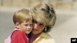 FILE - Princess Diana holds son Prince Harry while royal families posed for photographers at the Royal Palace in Mallorca, Spain, on Aug. 9, 1987.