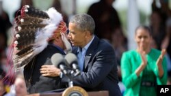 President Barack Obama with first lady Michelle Obama, Standing Rock Sioux Tribal Nation Chairman Dave Archambault II, in Cannon Ball, N.D., Friday, June 13, 2014, during a Cannon Ball flag day celebration, at the Cannon Ball powwow grounds.