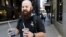 Adam Taylor, a sound engineer from Las Vegas, carries two glasses of iced coffee, responds to a question about new research showing that drinking coffee may boost chances for a longer life, even for those who down at least eight cups daily, July 2, 2018, in Chicago, Illinois.