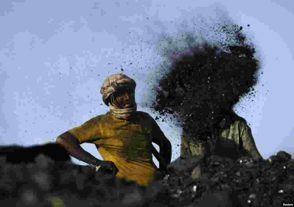 Laborers work at a coal dump site outside Kabul, Afghanistan.