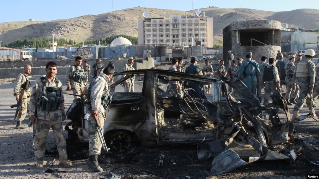 Pasukan khusus Afghanistan memeriksa mobil yang rusak akibat serangan bom di luar konsulat AS di kota Herat, Afghanistan (13/9).