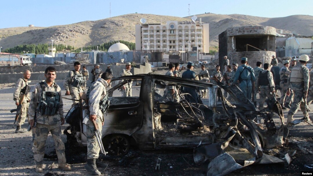 Petugas keamanan Afghanistan meriksa kendaraan yang rusak yang digunakan dalam serangan bom bunuh diri di luar konsulat AS di Herat (13//2013)