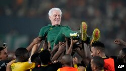 FILE — South Africa's head coach Hugo Broos is lifted up by players as they celebrate winning bronze at the 2023 African Cup of Nations after defeating DRC, at the Felix Houphouet-Boigny in Abidjan, Ivory Coast, on February 10, 2024.