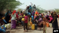 Yemenis gather next to a water tank to collect water in an impoverished coastal village on the outskirts of the Yemeni port city of Hodeidah, May 12, 2018.