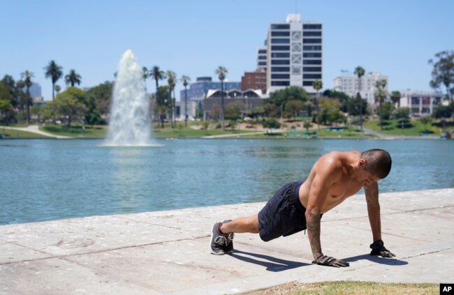A man exercises shirtless as temperatures rise at MacArthur Park, Tuesday, July 11, 2023, in Los Angeles. Los Angeles is expecting high temperatures between 100 to 110 degrees Fahrenheit later this week according to the National Weather Service. (AP Photo/Marcio Jose Sanchez)