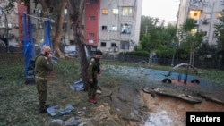 Israeli emergency services work at the scene of a missile strike, in Jaffa, south of Tel Aviv