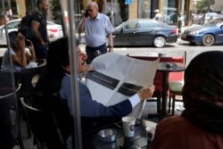 A man looks through a copy of the Lebanese local English-language newspaper, The Daily Star, in Beirut, Lebanon, Aug. 8, 2019.