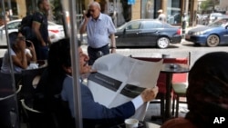 A man looks through a copy of the Lebanese local English-language newspaper, The Daily Star, in Beirut, Lebanon, Aug. 8, 2019. 
