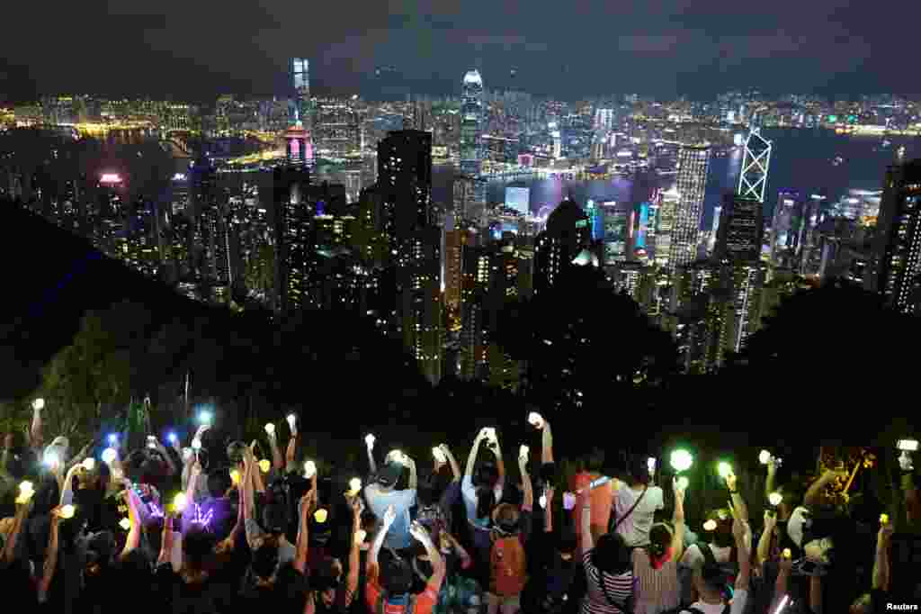 Anti-extradition bill protesters hold hands up to form a human chain during a rally to call for political reforms in Hong Kong, China.