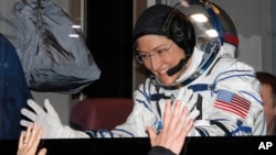 U.S. astronaut Christina Hammock Koch, member of the main crew of the expedition to the International Space Station, gestures to her relatives from a bus prior the launch of Soyuz MS-12 space ship, Baikonur cosmodrome, Kazakhstan, March 14, 2019. 