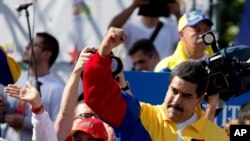 Le président du Venezuela Nicolas Maduro salue ses supporters lors de la "Marche anti-USA" le 15 décembre 2014.