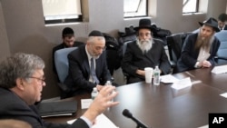 FILE - Attorney General William Barr, left, talks with Rabbi Chaim David Zweibel, second left, Rabbi David Niederman, second right, and Rabbi Eli Cohen to step up their efforts to combat anti-Semitic hate crimes, Jan. 28, 2020, in New York.