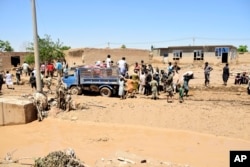 People receive food after heavy flooding in Baghlan province, Afghanistan, on May 12, 2024.