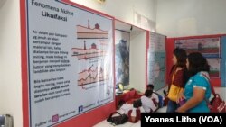 Pengunjung Museum membaca penjelasan Fenomena Akibat Likuefaksi dalam kegiatan pameran sejarah alam dan kebencanaan Sulawesi Tengah, 8 Oktober 2019. (Foto: VOA/Yoanes Litha)