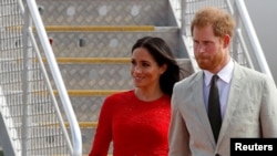 Pangeran Harry (kanan) dan Meghan tiba di bandara Fua'amotu, Tongatapu di Tonga, 25 Oktober 2018. (REUTERS/Phil Noble). 