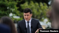 Ukrainian President Volodymyr Zelenskiy gestures during an open-air news conference, one year after his inauguration, amid the outbreak of the coronavirus disease in Kyiv, May 20, 2020.