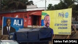 Les affiches de la campagne électorale du président gabonais sortant Ali Bongo et de son rival Jean Ping de l’opposition, sont côte-à-côte, à Libreville, 26 août 2016. VOA/Idriss Fall 