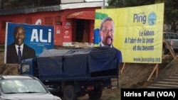 Les affiches de la campagne électorale du président gabonais sortant Ali Bongo et de son rival Jean Ping de l’opposition, sont côte-à-côte, à Libreville, 26 août 2016. VOA/Idriss Fall 