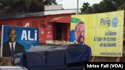 Les affiches de la campagne électorale du président gabonais sortant Ali Bongo et de son rival Jean Ping de l’opposition, sont côte-à-côte, à Libreville, 26 août 2016. VOA/Idriss Fall 