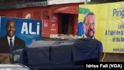 Les affiches de la campagne électorale du président gabonais sortant Ali Bongo et de son rival Jean Ping de l’opposition, sont côte-à-côte, à Libreville, 26 août 2016. VOA/Idriss Fall 