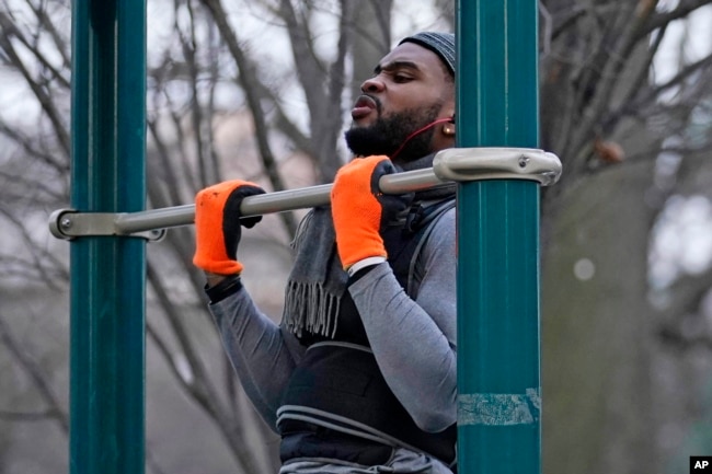 FILE - Zay Frection works out in "the gym" at Fort Greene Park, Thursday, Dec. 23, 2020, in the Brooklyn borough of New York. (AP Photo/Kathy Willens) Size: