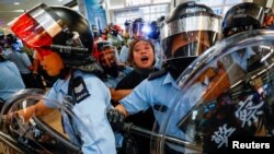 Polisi anti huru-hara menangkap seorang perempuan yang ikut dalam protes anti-pemerintah di stasiun MTR Sha Tin, Hong Kong, 25 September 2019. 